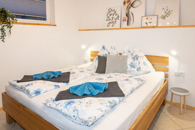 Doppelbett aus Massivholz mit frischen Handtüchern