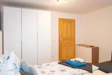 Schlafzimmer mit Doppelbett und großem Kleiderschrank