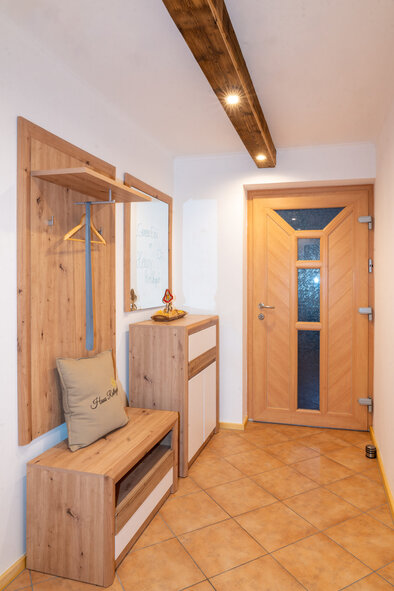 Eingangsbereich mit Holzgarderobe und Sitzbank